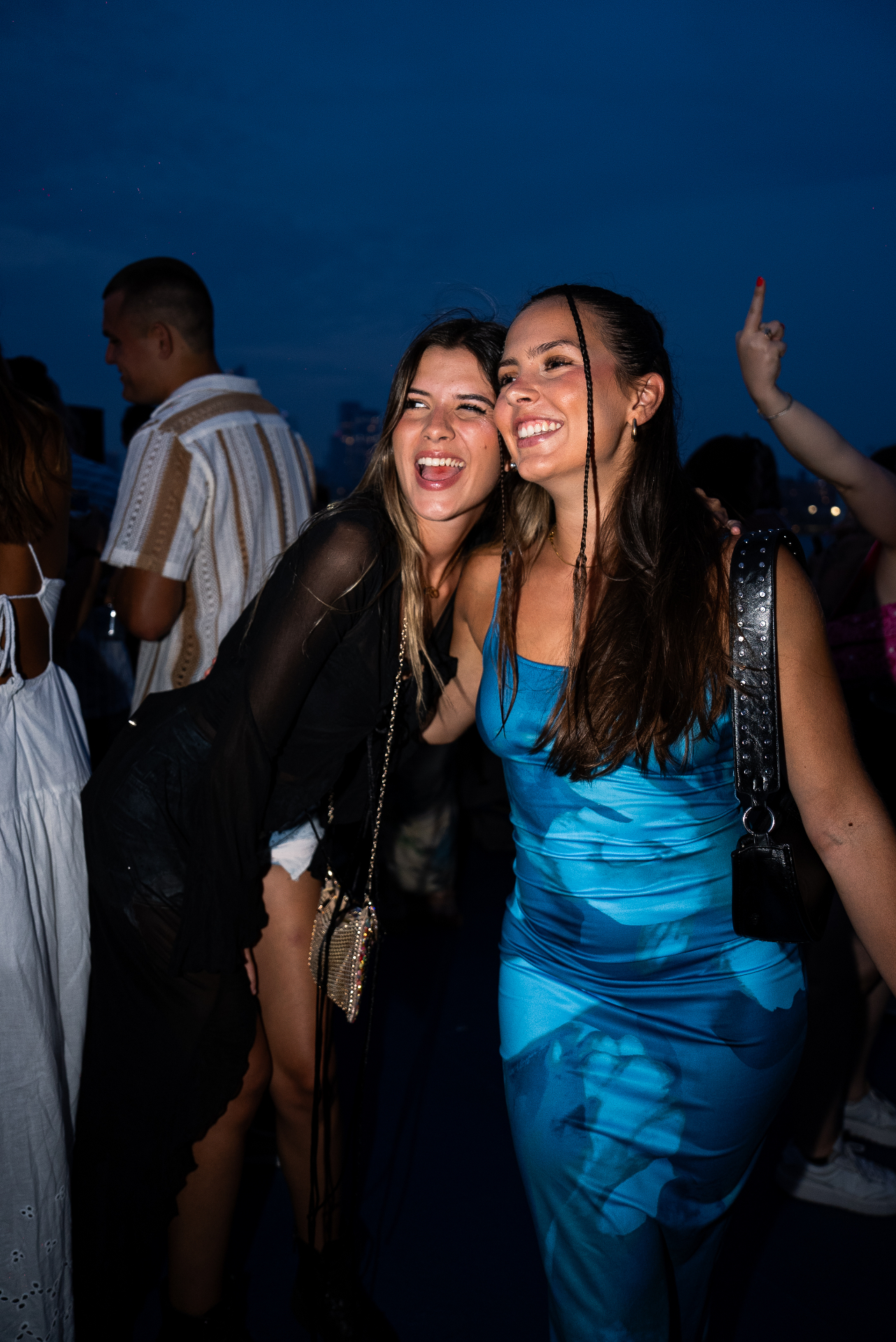 Friends celebrating on a private NYC yacht at night with the skyline behind them